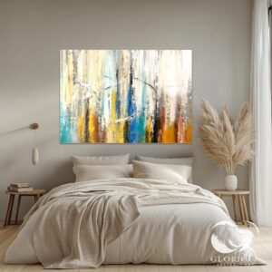 Horizontal abstract painting with blue and gold tones styled above a bed.