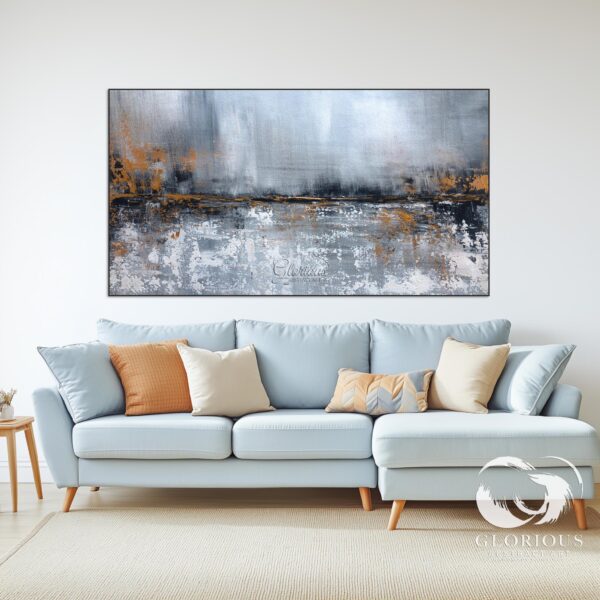 Gray and gold abstract painting above a sofa in a modern living room.