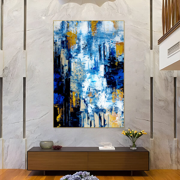 Large abstract ocean painting with blue, white, and gold tones.