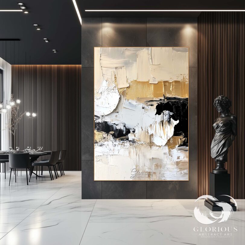 Modern abstract canvas art in beige, black, and gold tones hanging in a minimalist office space