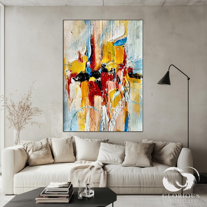 Abstract painting with red, yellow, and blue brushstrokes hanging in a minimalist space