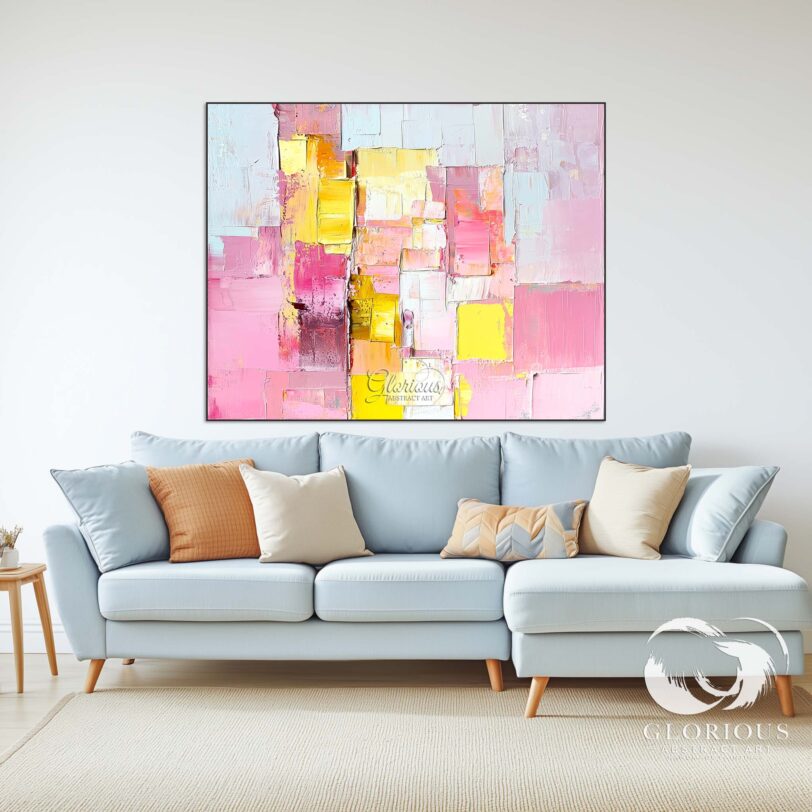 Large textured abstract painting in pink and yellow hung in a stylish living room.